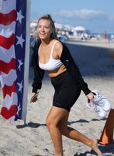 Camille Kostek wears a white bikini top as she rides a jet ski in Miami