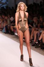 Kate Upton in a gold one-piece bathing suit at Beach Bunny Swimwear during Miami Swim Week in Miami Beach