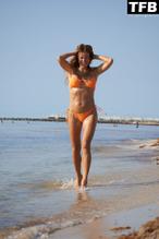 Kelly BensimonSexy in Kelly Bensimon Sexy Poses Showcasing Her Hot Figure Wearing An Orange Bikini On The Beach In A Photoshoot 