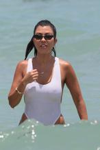 Kourtney Kardashian Sexy in Kourtney Kardashian Sexy in  a white one piece swimsuit on the beach in Miami